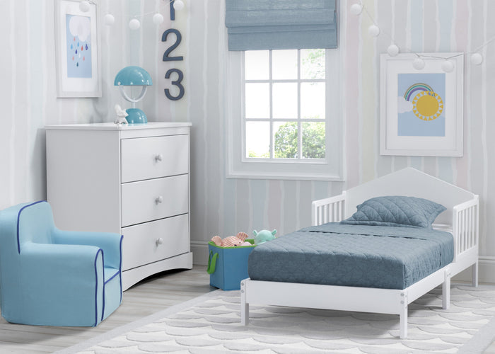 Children's bedroom with white crib, blue chair, and dresser in a bright room.