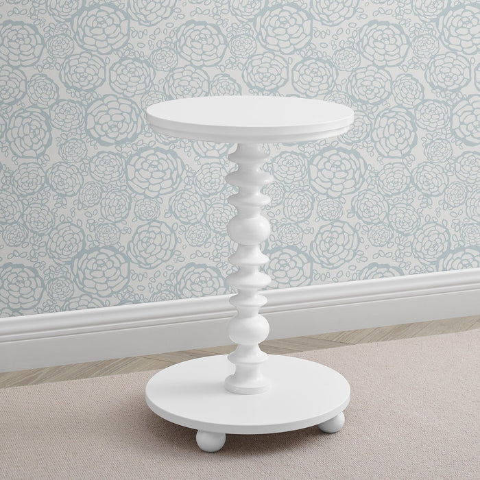 White side table against a floral wallpapered wall