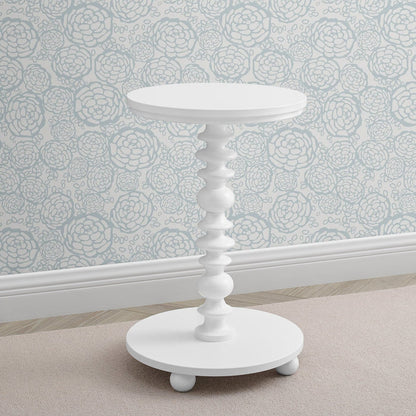 White side table against a floral wallpapered wall