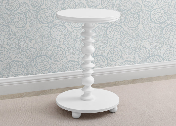 White side table with decorative design on a light-colored floor and patterned wall.